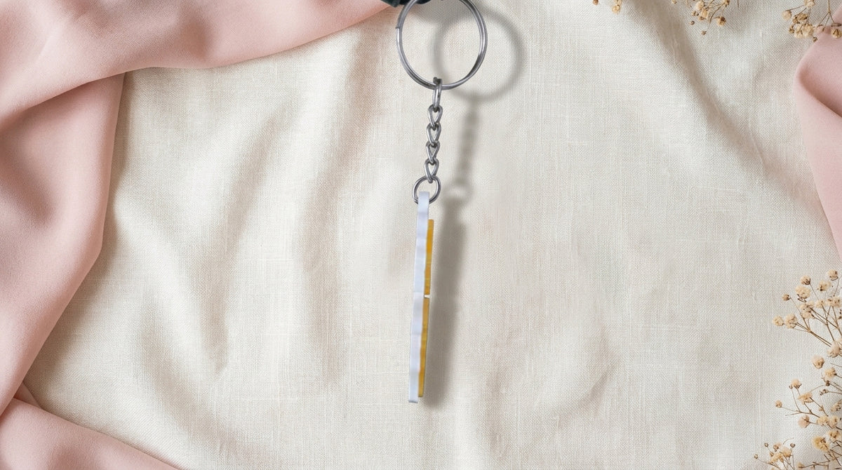 Side view of Yellow NameLoop personalized name keychain hanging from the included keyring