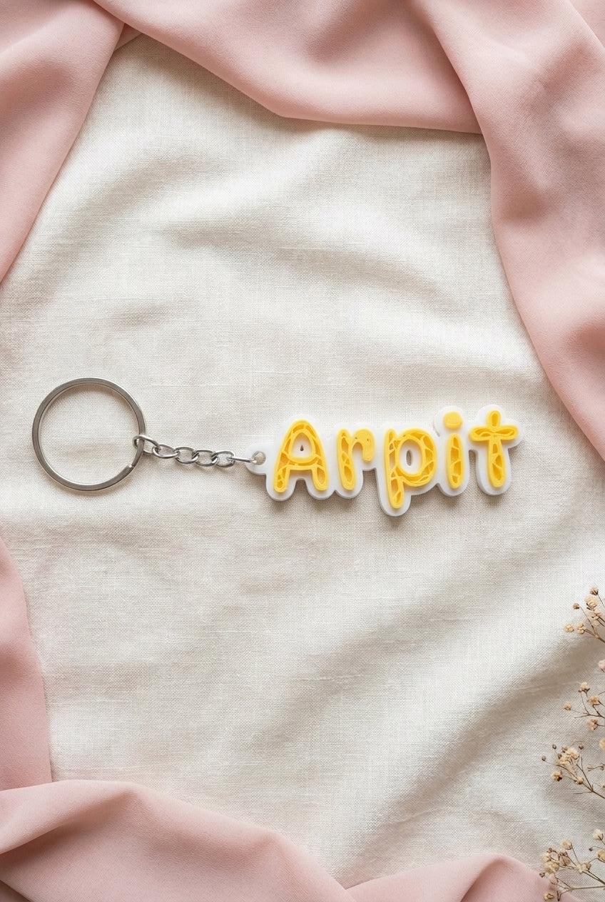 Yellow NameLoop name keychain with white outline and included keyring, front flat-lay view