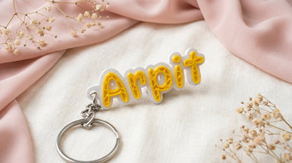 Angled front view of Yellow NameLoop personalized name keychain and included keyring